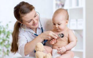 Cute woman pediatrician examining of baby kid with stethoscope